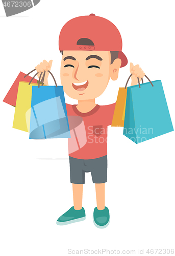 Image of Happy caucasian boy holding shopping bags.