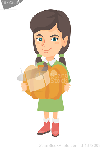Image of Caucasian girl standing with a big orange pumpkin.