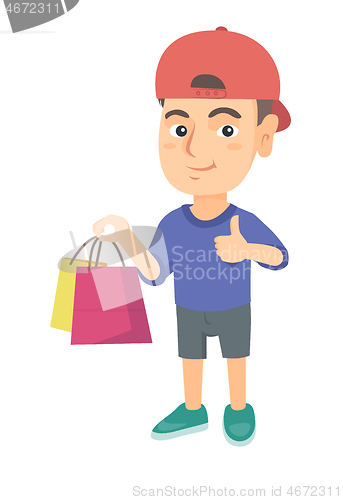 Image of Happy caucasian boy holding shopping bags.