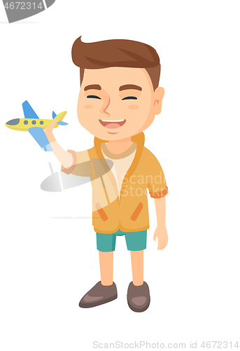 Image of Caucasian cheerful boy playing with a toy airplane