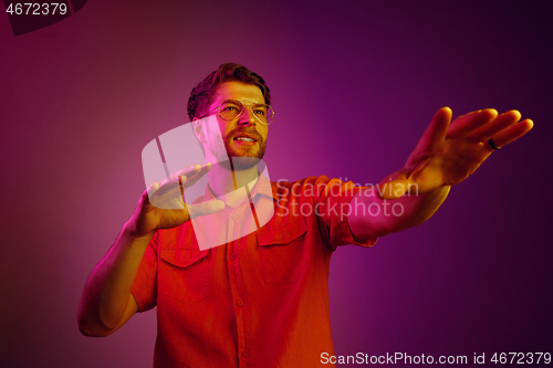 Image of The happy business man standing and smiling against pink background.