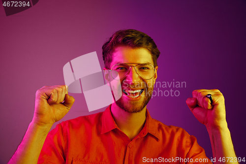 Image of The happy business man standing and smiling against pink background.