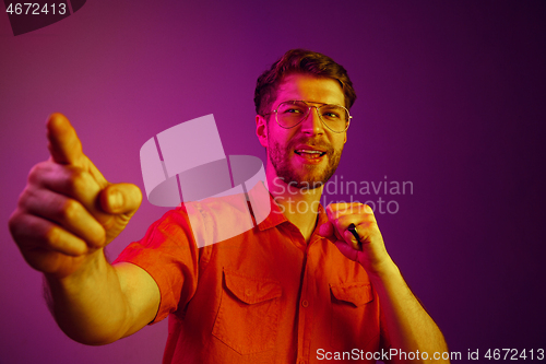 Image of The happy business man standing and smiling against pink background.