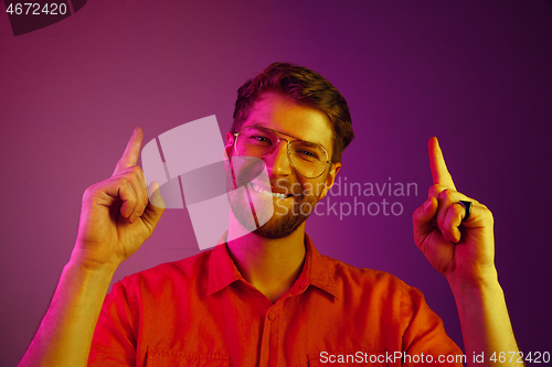 Image of The happy business man standing and smiling against pink background.