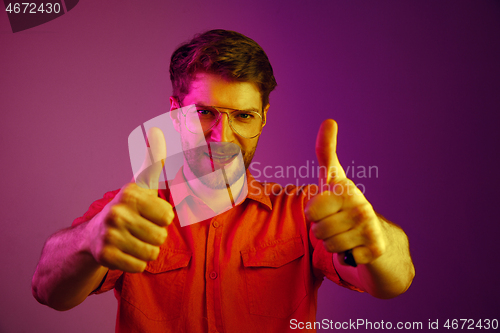 Image of The happy business man standing and smiling against pink background.