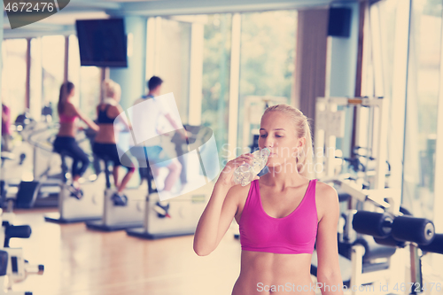 Image of woman in fitness gym drink water