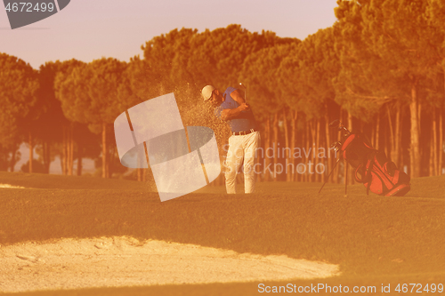 Image of golfer hitting a sand bunker shot on sunset