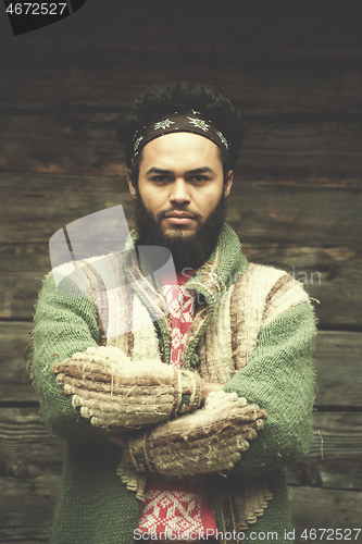 Image of portrait of young hipster in front of wooden house