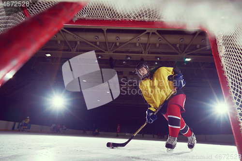 Image of teen ice hockey player in action