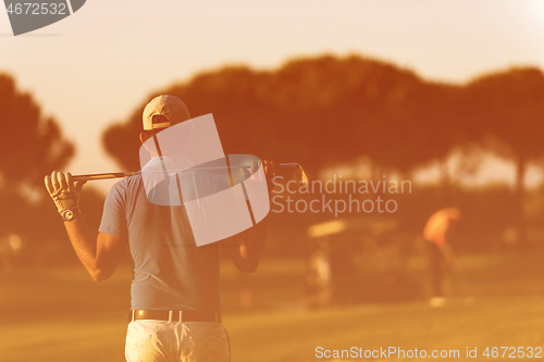 Image of golfer from back at course looking to hole in distance