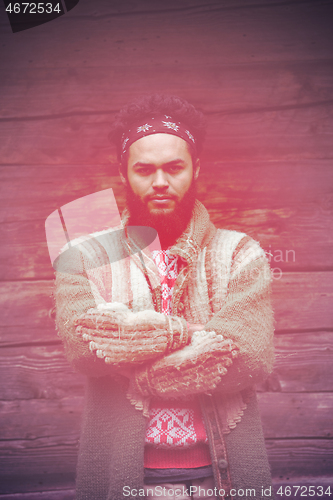 Image of portrait of young hipster in front of wooden house