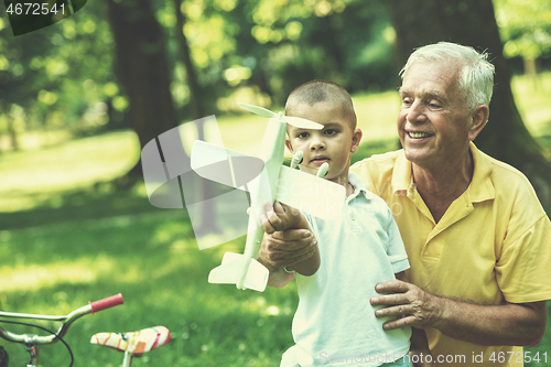 Image of grandfather and child have fun  in park