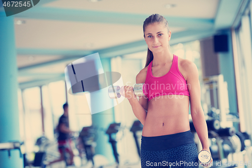 Image of lifting some weights and working on her biceps in a gym