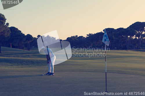 Image of golfer hitting ball to hole