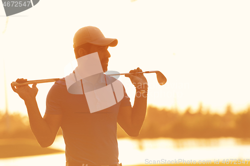 Image of golfer  portrait at golf course on sunset