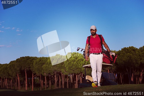 Image of golfer  walking and carrying golf  bag