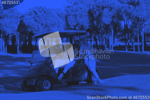 Image of couple in buggy on golf course