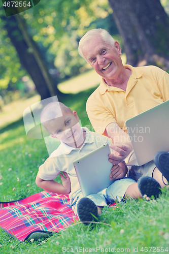 Image of grandfather and child using laptop