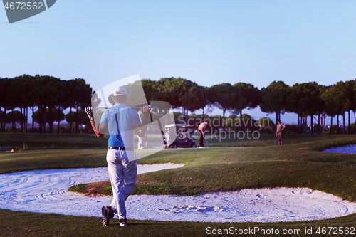 Image of golfer from back at course looking to hole in distance