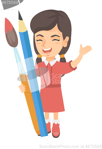 Image of Smiling girl holding big pencil and paintbrush.