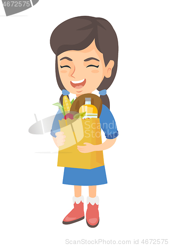 Image of Girl holding paper shopping bag full of groceries.