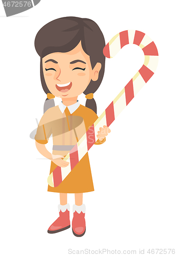 Image of Caucasian little girl holding christmas candy cane