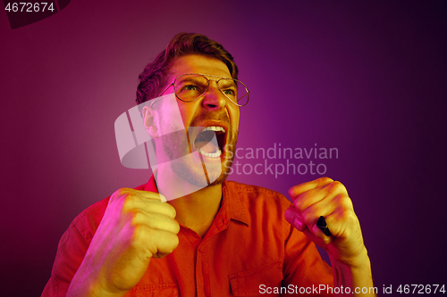 Image of The young emotional angry man screaming on pink studio background