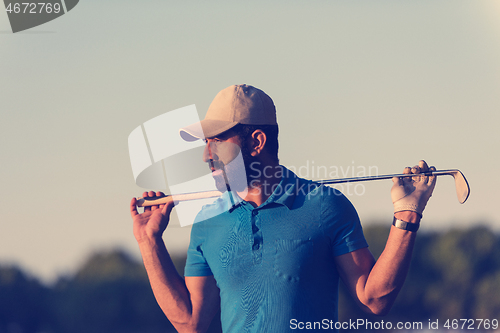 Image of golfer  portrait at golf course on sunset