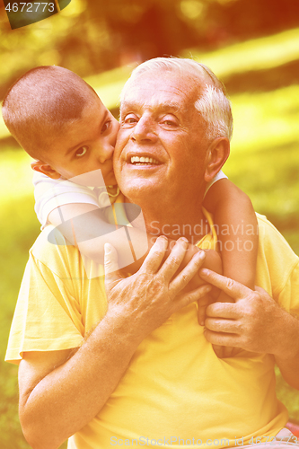 Image of grandfather and child have fun  in park