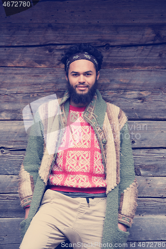 Image of portrait of young hipster in front of wooden house