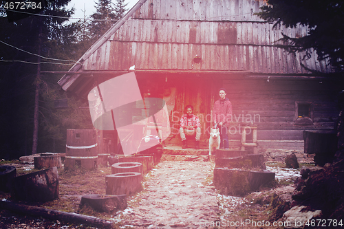 Image of frineds together in front of old wooden house