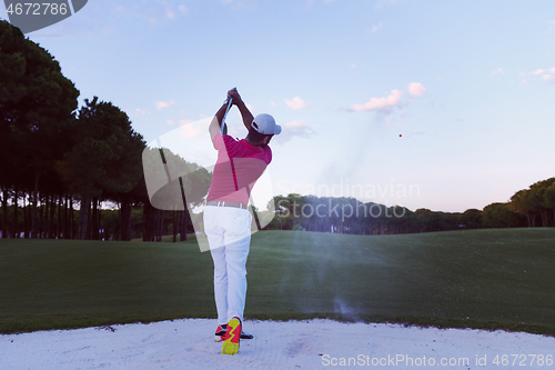 Image of golfer hitting a sand bunker shot on sunset