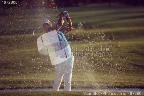 Image of golfer hitting a sand bunker shot on sunset