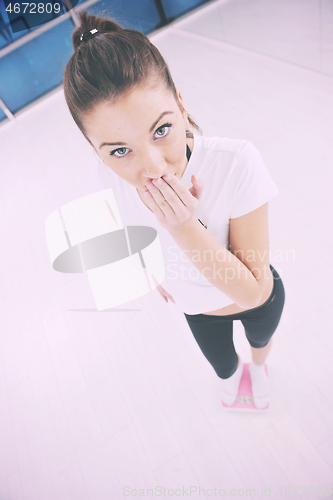 Image of happy diet concept with young woman on pink scale