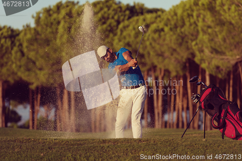 Image of golfer hitting a sand bunker shot on sunset