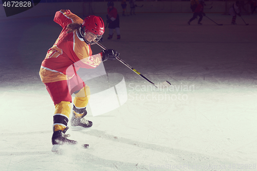 Image of teen ice hockey player in action