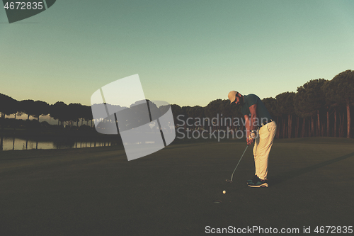 Image of golfer  hitting shot at golf course