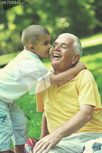 Image of happy grandfather and child in park
