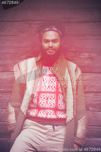 Image of portrait of young hipster in front of wooden house