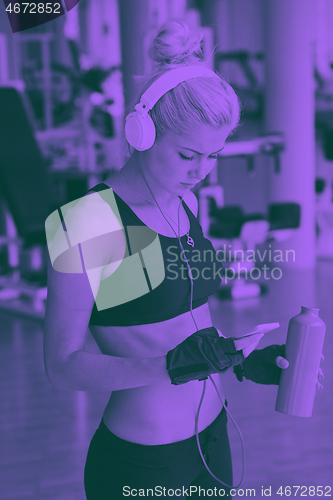 Image of woman with headphones in fitness gym