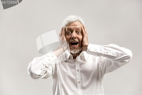 Image of The senior man looking suprised isolated on gray