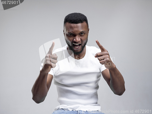 Image of The young emotional angry man screaming on gray studio background