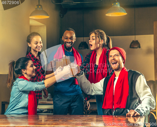 Image of Sport, people, leisure, friendship and entertainment concept - happy football fans or male friends drinking beer and celebrating victory at bar or pub