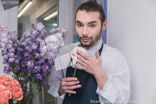 Image of Small business. Male florist in flower shop. Floral design studio, making decorations and arrangements.