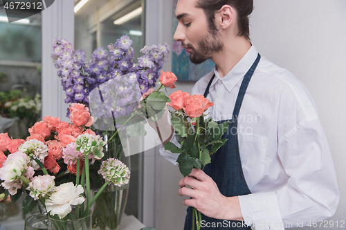 Image of Small business. Male florist in flower shop. Floral design studio, making decorations and arrangements.