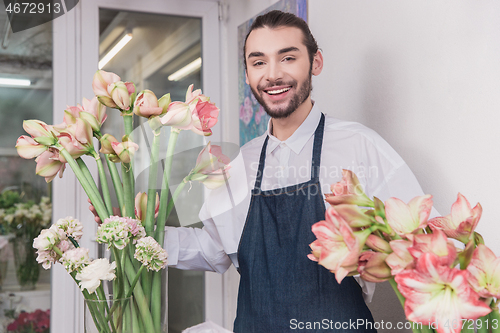 Image of Small business. Male florist in flower shop. Floral design studio, making decorations and arrangements.