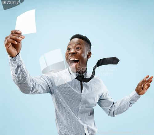 Image of Young boy with a surprised expression won a bet on blue background