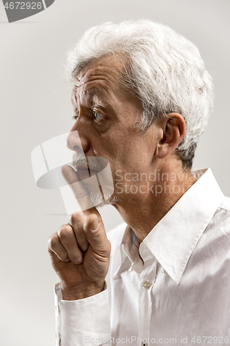 Image of Serious frightened male keeps fore finger on lips