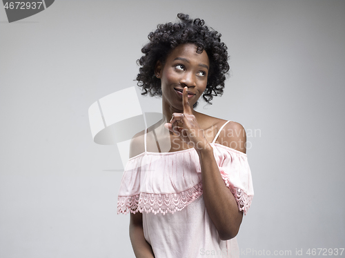 Image of The young woman whispering a secret behind her hand