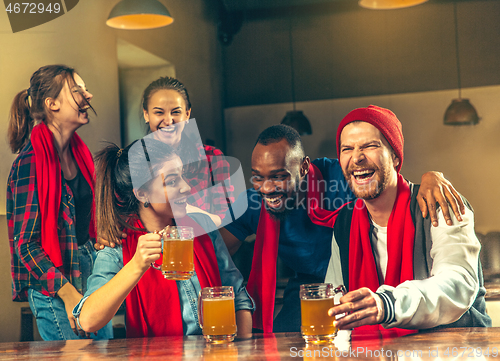 Image of Sport, people, leisure, friendship and entertainment concept - happy football fans or male friends drinking beer and celebrating victory at bar or pub